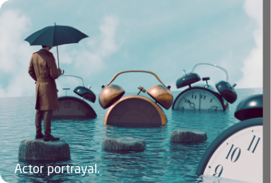 Man standing on a stone surrounded by water holding an umbrella and watching alarm clocks sink