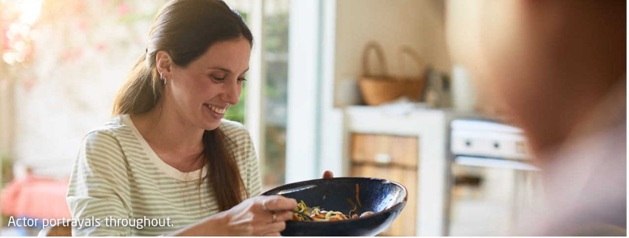 Woman smiling and holding a bowl of food