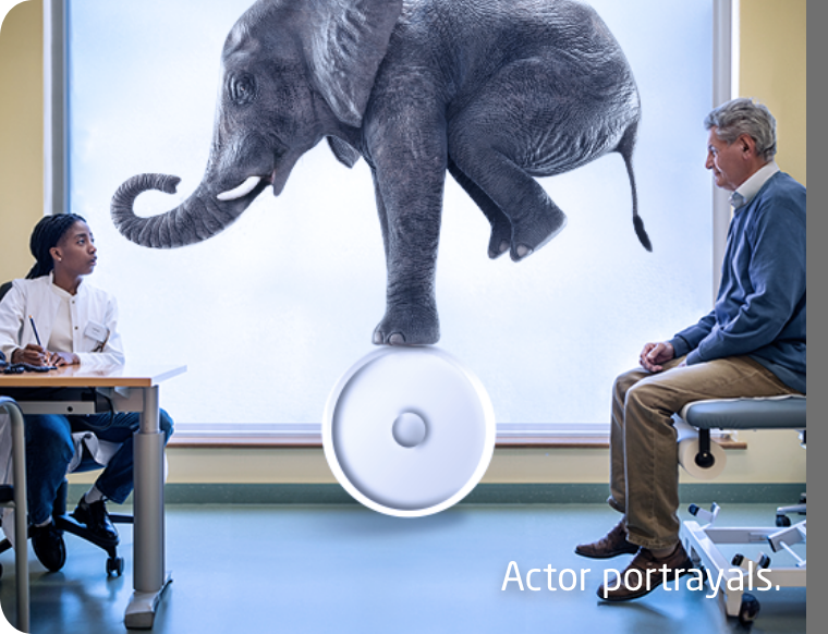 Doctor and patient sitting in office with an elephant balancing on a ball between them