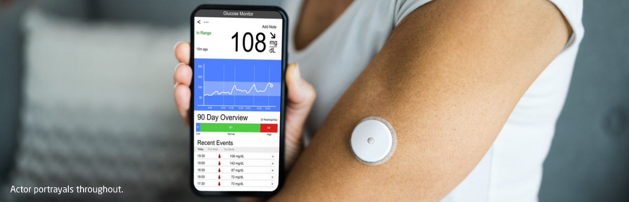 Person showing cell phone screen displaying diabetes data