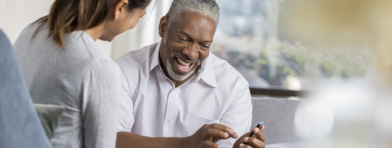 Man and woman looking at cell phone and smiling